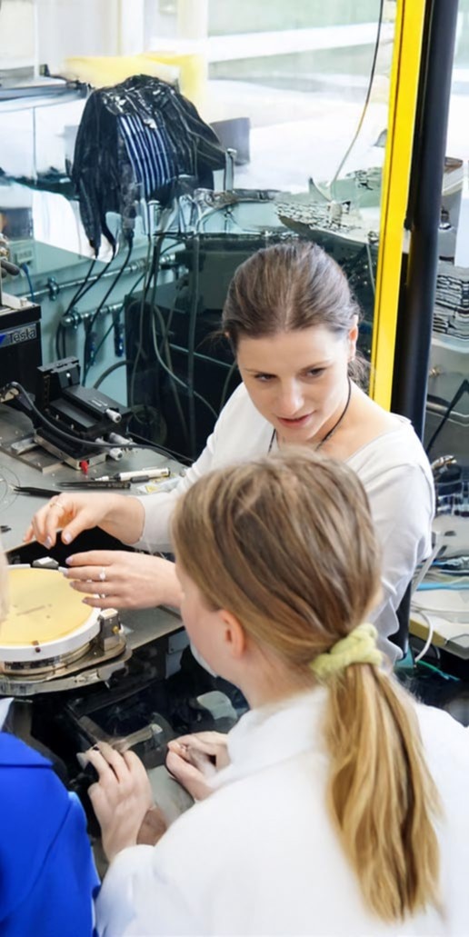 Two young women trying to create something with their hands.