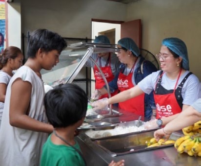 onsemi employees standing by a pile of food they collected to help others.
